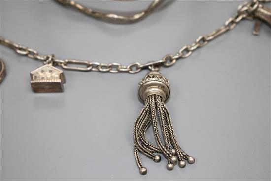 A modern silver and niello serpent bangle and a white metal tassle bracelet hung with four assorted charms, gross weight 65 grams.